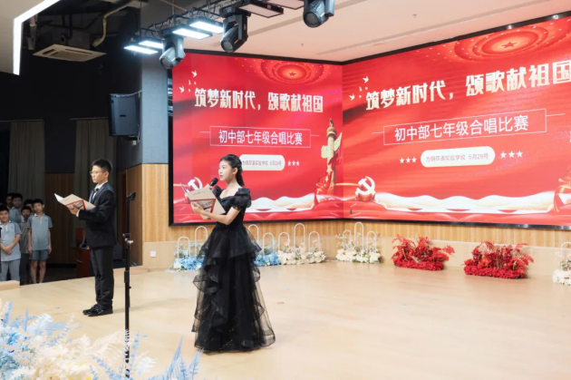 5月29日晚，寶安區(qū)為明初中部舉辦“筑夢新時(shí)代，頌歌獻(xiàn)祖國”七年級合唱大賽?；顒釉谇f嚴(yán)的國歌聲中拉開帷幕。九個(gè)班級以青春之聲，向時(shí)代致敬，為祖國獻(xiàn)歌，用激昂澎湃的旋律，激蕩起全場熾熱的愛國情懷。